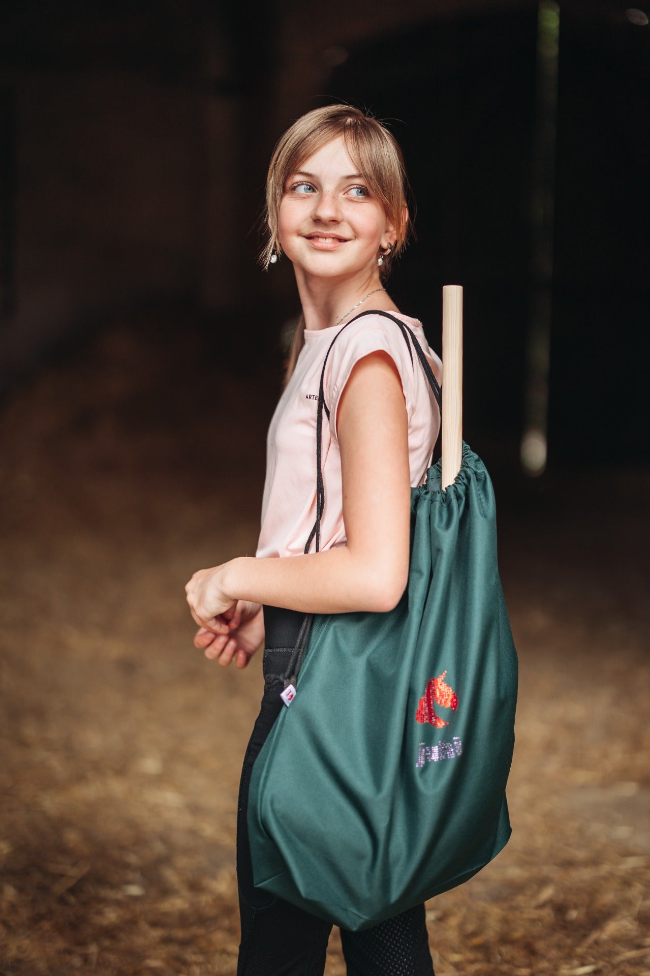 Tmavě zelený nepromokavý vak na přenášení hobby horse se stahovací šňůrkou a logem JUHI.
