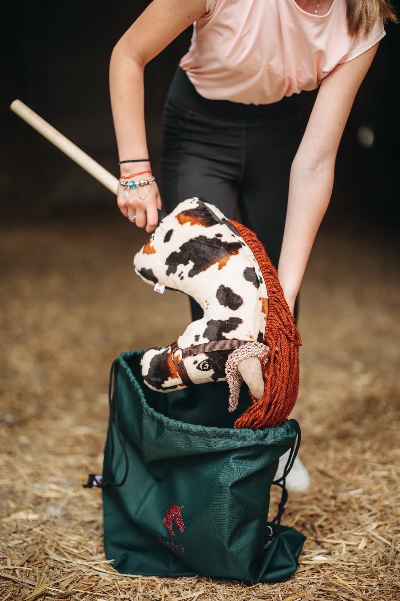 Tmavě zelený nepromokavý vak na přenášení hobby horse se stahovací šňůrkou a logem JUHI.