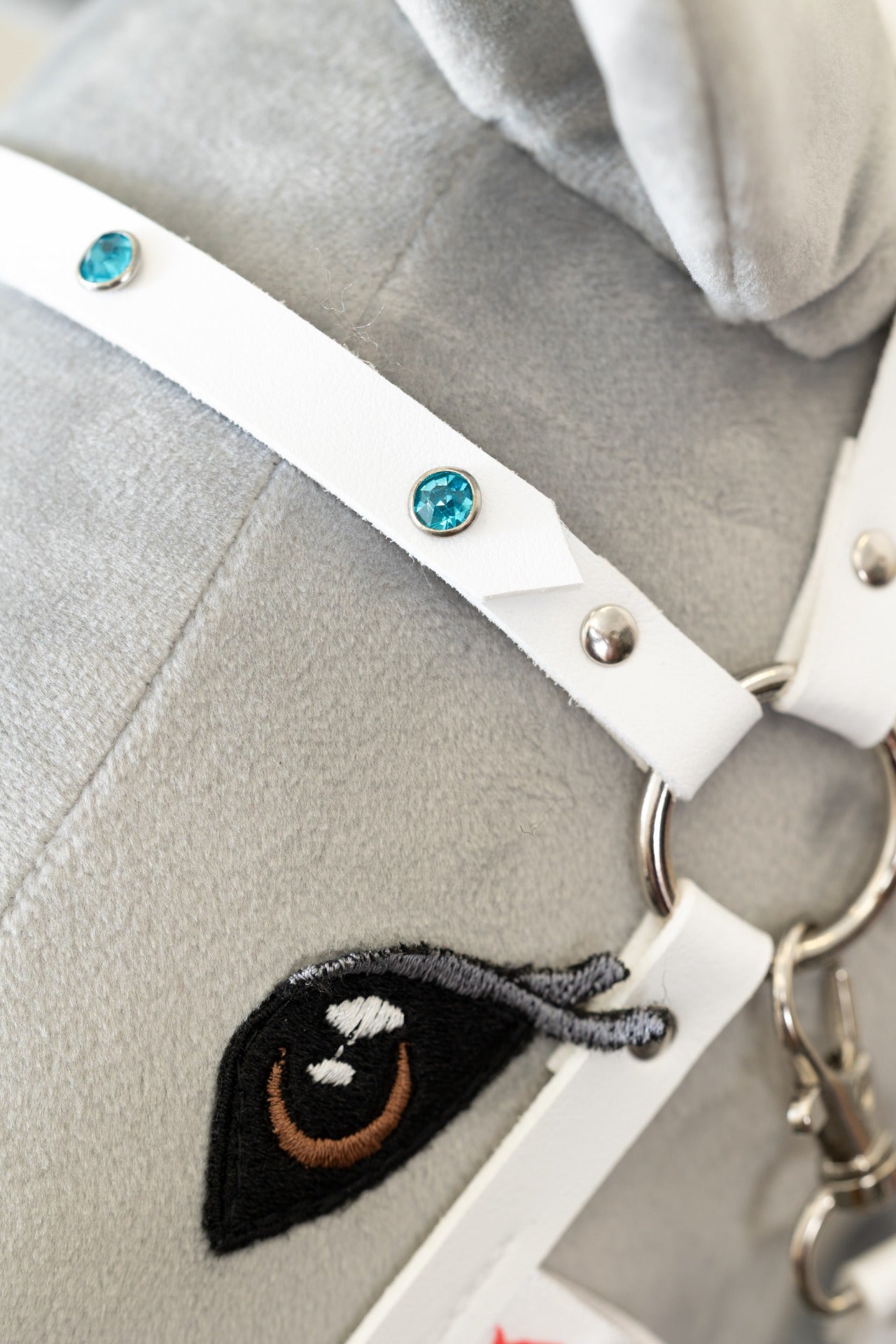 Bílá ohlávka "Crystal" pro hobby horse, zdobená třpytivými kamínky se stříbrným kováním, na bílém koníkovi.